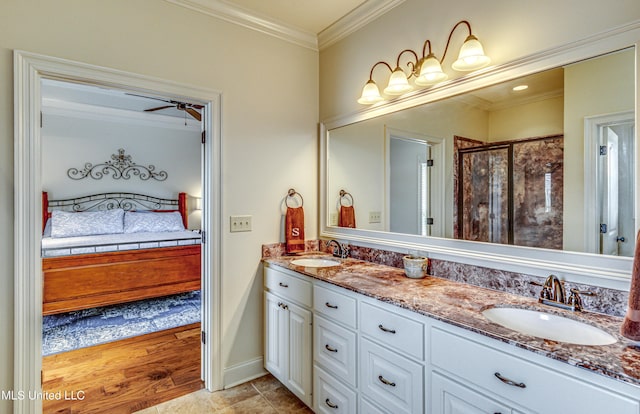 ensuite bathroom with crown molding, connected bathroom, a sink, and a stall shower