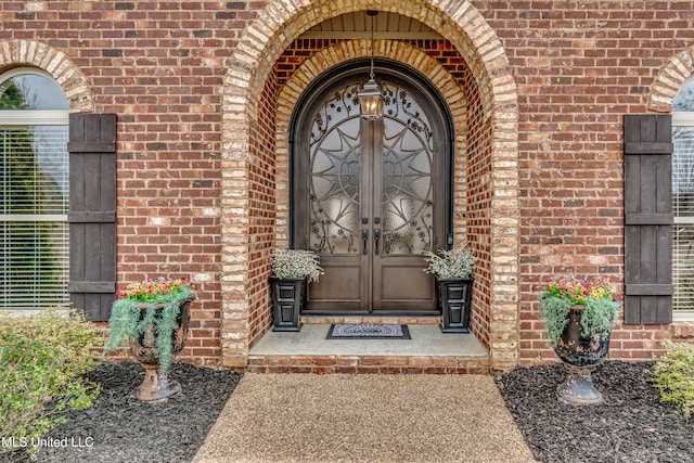 view of exterior entry with french doors and brick siding