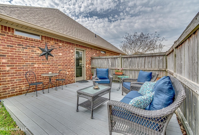 wooden terrace with a fenced backyard and an outdoor living space