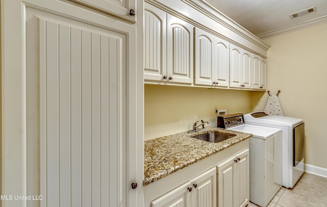 clothes washing area featuring cabinet space, light tile patterned floors, visible vents, crown molding, and a sink