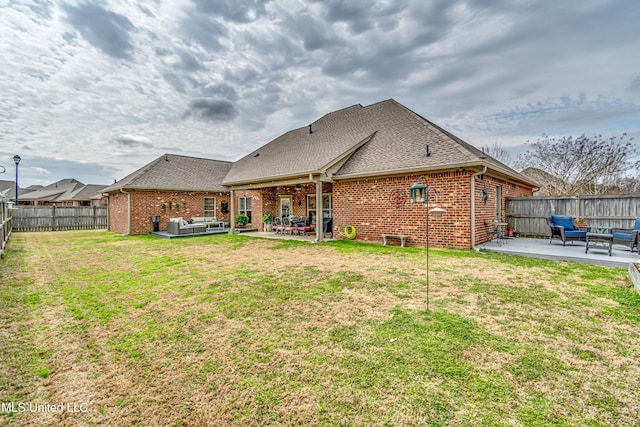 back of house with a fenced backyard, brick siding, outdoor lounge area, a lawn, and a patio area