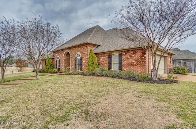 view of front facade with a garage, a shingled roof, a front lawn, and brick siding