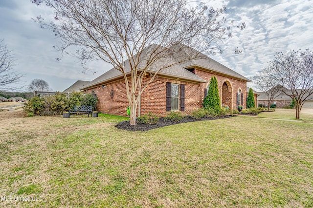 view of front of property featuring a front lawn and brick siding