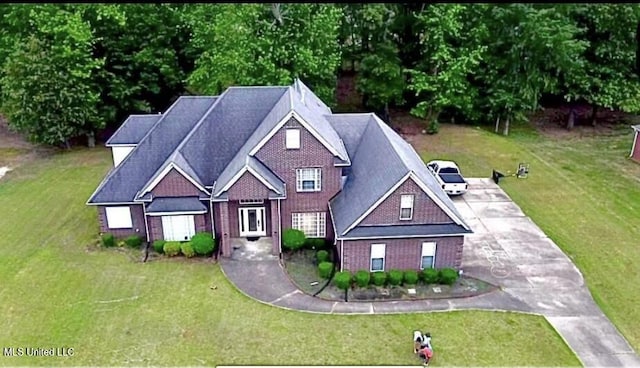 view of front of property with a front lawn and brick siding