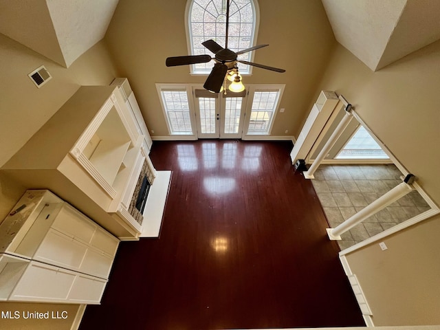 unfurnished living room featuring high vaulted ceiling, wood finished floors, visible vents, and baseboards