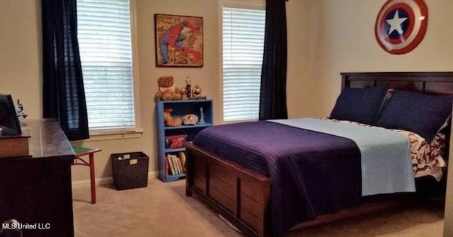 bedroom with baseboards and light colored carpet