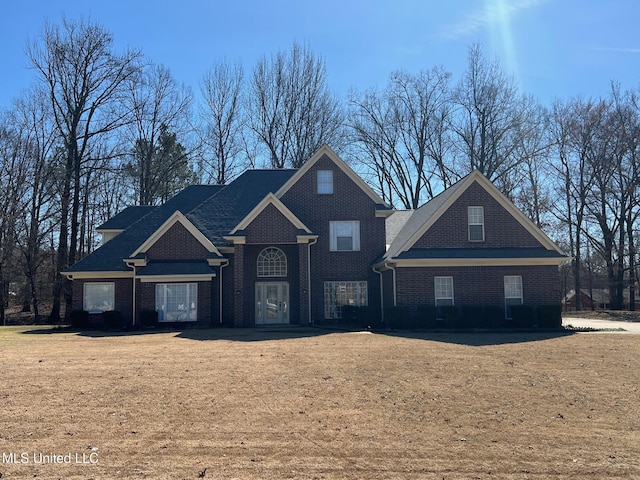 traditional-style home with brick siding and a front yard