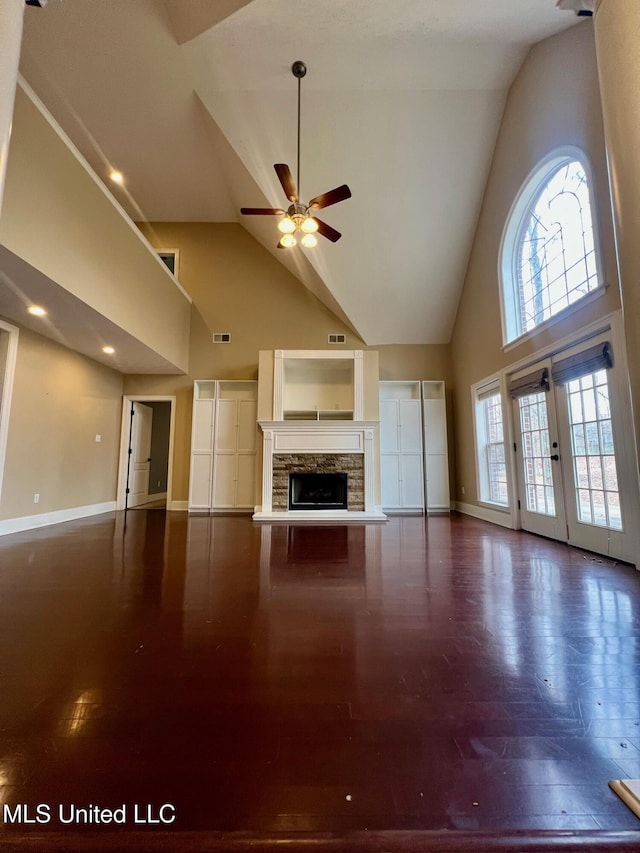 unfurnished living room featuring dark wood-style flooring, a ceiling fan, and baseboards