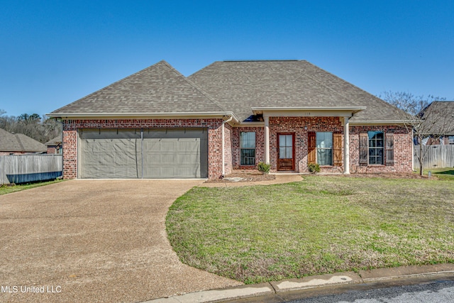 view of front facade featuring a front lawn, fence, roof with shingles, an attached garage, and brick siding