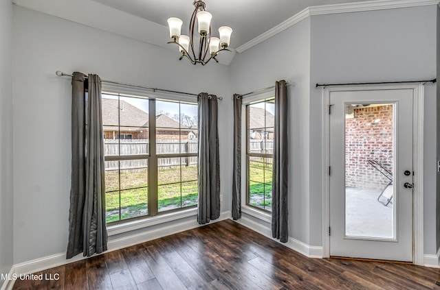 unfurnished dining area featuring a notable chandelier, dark wood-style floors, baseboards, and ornamental molding