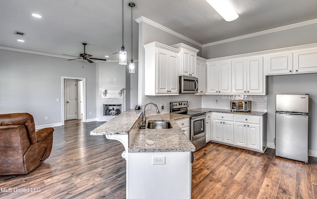 kitchen with visible vents, a peninsula, a sink, stainless steel appliances, and open floor plan