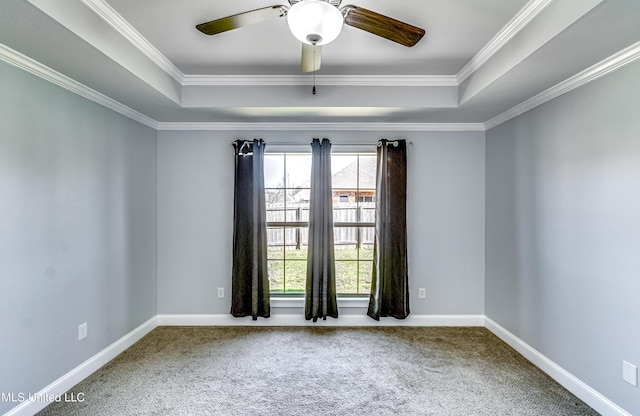 spare room featuring a tray ceiling, carpet, and crown molding