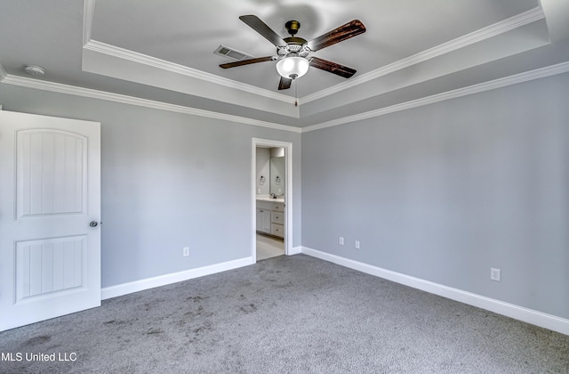 unfurnished bedroom with carpet, visible vents, baseboards, ornamental molding, and a raised ceiling