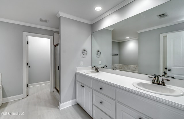 bathroom with a sink, visible vents, and ornamental molding