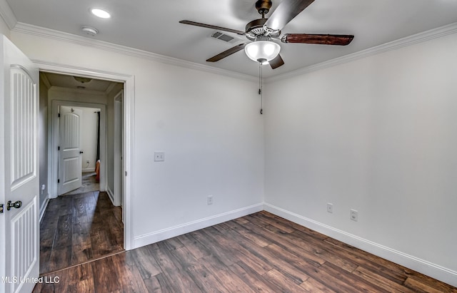 empty room with baseboards, visible vents, dark wood-style flooring, and ornamental molding