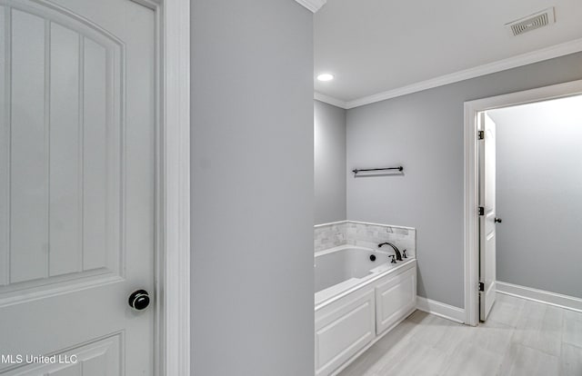 bathroom with baseboards, visible vents, recessed lighting, ornamental molding, and a garden tub