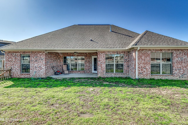 back of house featuring brick siding, a shingled roof, a lawn, a patio area, and a ceiling fan