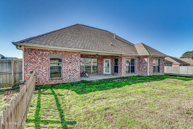 back of property with a patio area, brick siding, a shingled roof, and fence