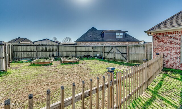 view of yard featuring fence and a garden