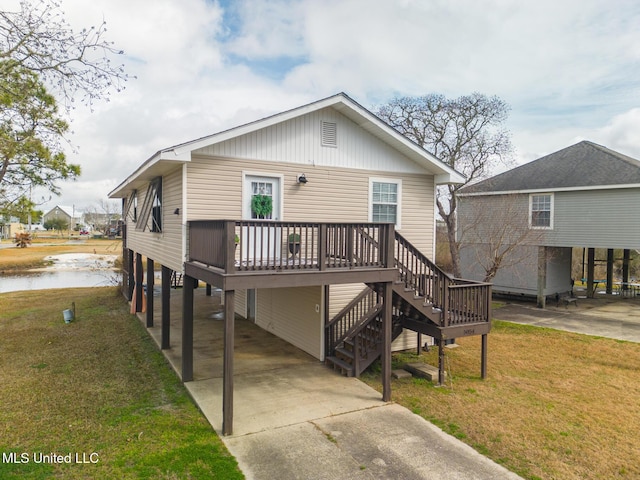 beach home with a carport, a wooden deck, and a front yard