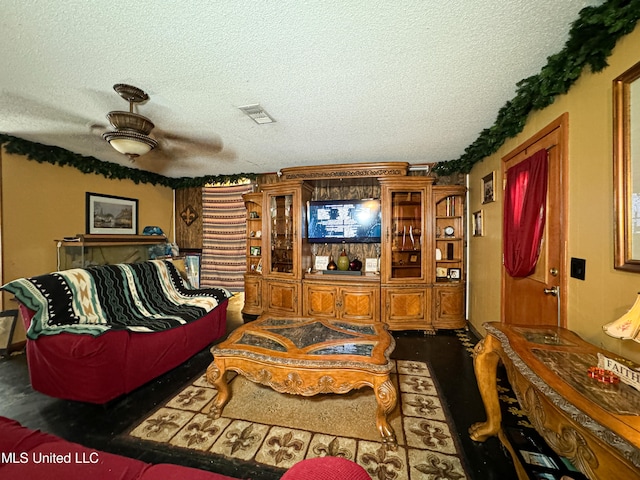 living room featuring hardwood / wood-style flooring, a textured ceiling, and ceiling fan