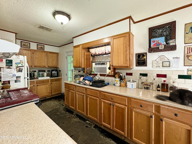 kitchen featuring backsplash, range, a textured ceiling, white fridge, and ornamental molding