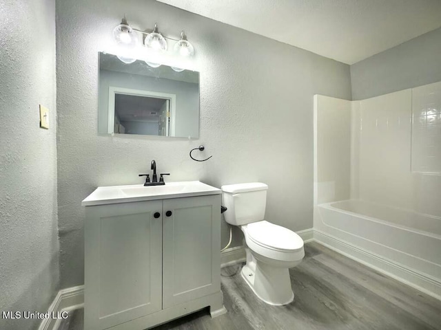 full bathroom with toilet, shower / washtub combination, hardwood / wood-style flooring, and vanity