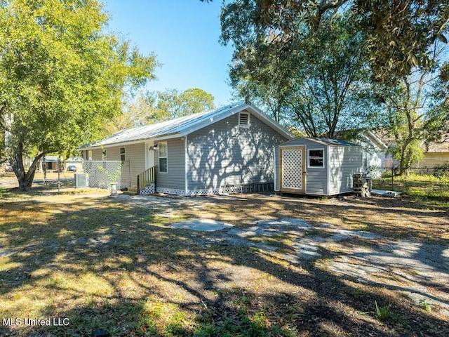 back of house with a shed and central air condition unit