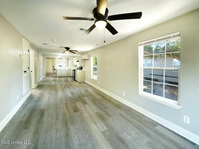 unfurnished living room with a textured ceiling and wood-type flooring