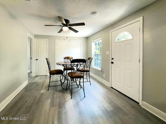 dining space featuring ceiling fan, a textured ceiling, and dark hardwood / wood-style flooring