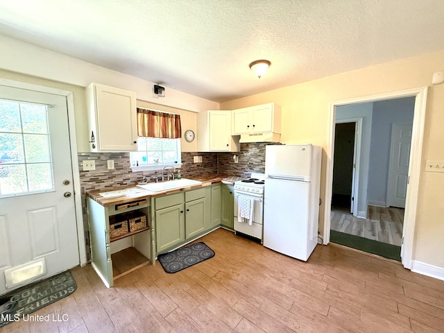 2006 Eden St, Pascagoula, MS 39581 - kitchen featuring white appliances, a sink, under cabinet range hood, tasteful backsplash, and light wood-type flooring