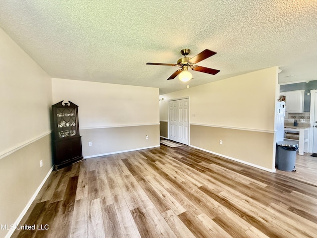 2006 Eden St, Pascagoula, MS 39581 - unfurnished living room featuring wood finished floors, a ceiling fan, a textured ceiling, and baseboards
