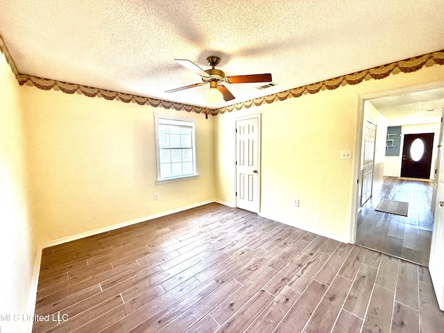 2006 Eden St, Pascagoula, MS 39581 - spare room with wood finished floors, a textured ceiling, ceiling fan, and baseboards