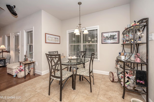 dining room featuring baseboards, an inviting chandelier, and light tile patterned floors