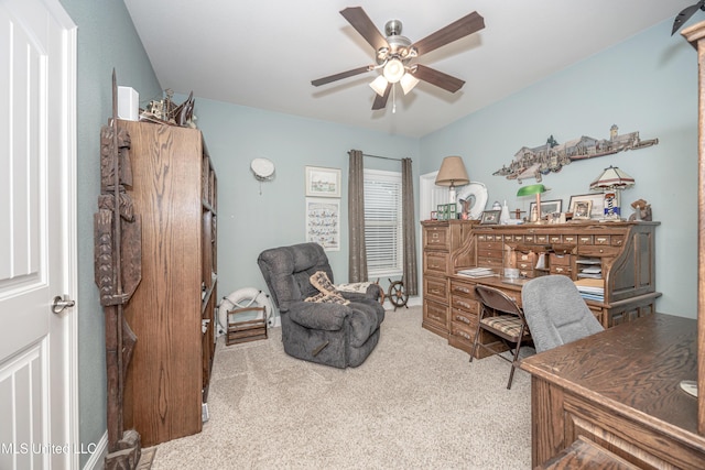 carpeted office with a ceiling fan