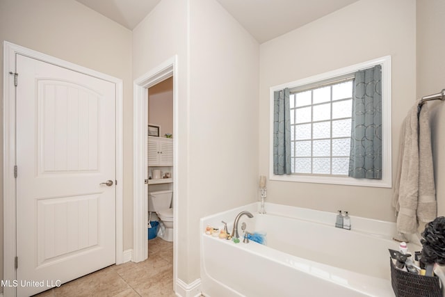 full bath with tile patterned floors, a garden tub, and toilet