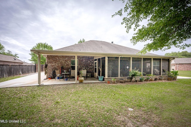 back of property featuring fence, a sunroom, a yard, and a patio