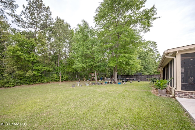 view of yard with a fenced backyard and a sunroom