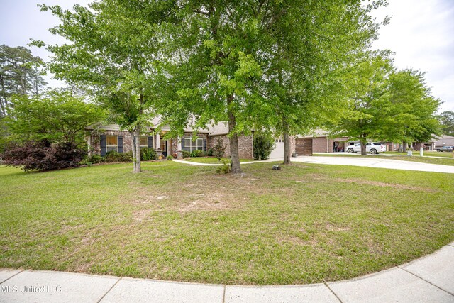 view of property hidden behind natural elements with brick siding, an attached garage, driveway, and a front lawn