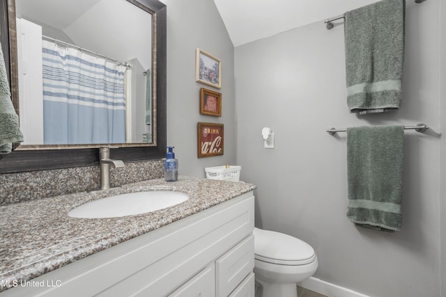 bathroom with vanity, toilet, and vaulted ceiling