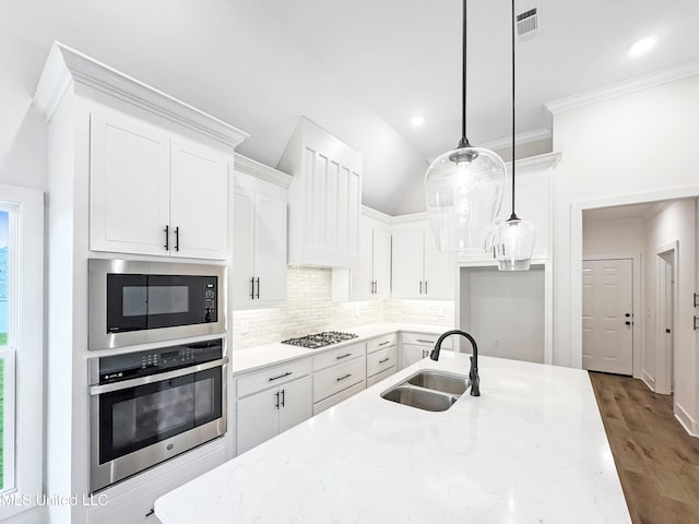 949 Mullican Rd, Florence, MS 39073 - kitchen with appliances with stainless steel finishes, a sink, decorative backsplash, white cabinets, and ornamental molding