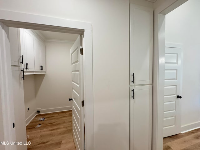 laundry room with cabinets, ornamental molding, hookup for an electric dryer, and light hardwood / wood-style floors