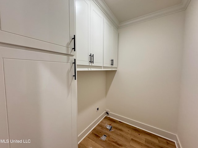 washroom featuring cabinets, wood-type flooring, ornamental molding, and hookup for an electric dryer