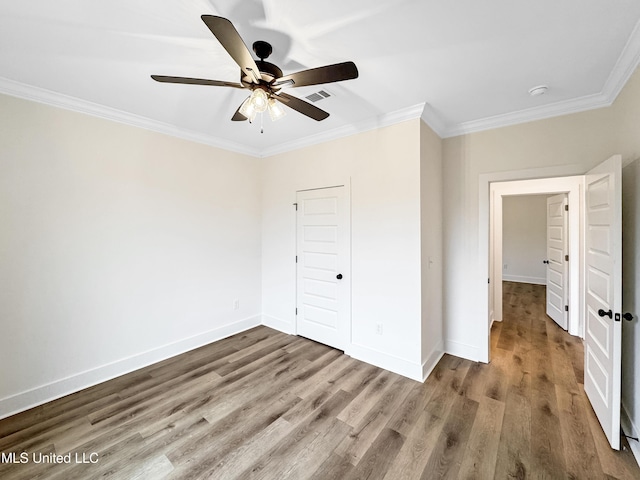 949 Mullican Rd, Florence, MS 39073 - unfurnished bedroom with crown molding, wood finished floors, baseboards, a closet, and ceiling fan