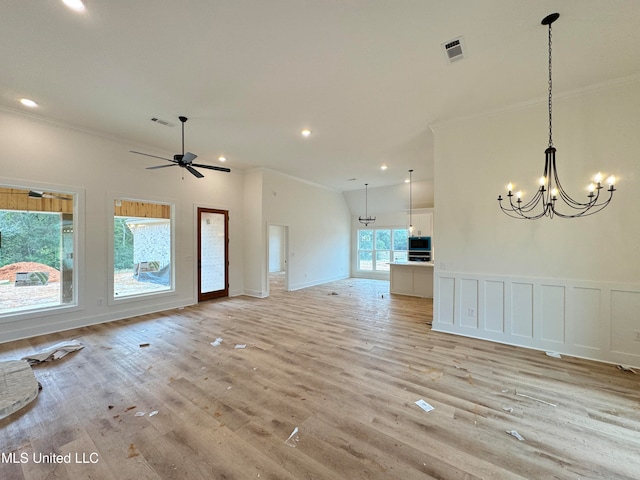 unfurnished living room featuring vaulted ceiling, ornamental molding, ceiling fan with notable chandelier, and light wood-type flooring