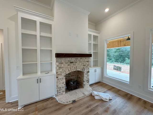 unfurnished living room with a fireplace, light hardwood / wood-style flooring, and ornamental molding