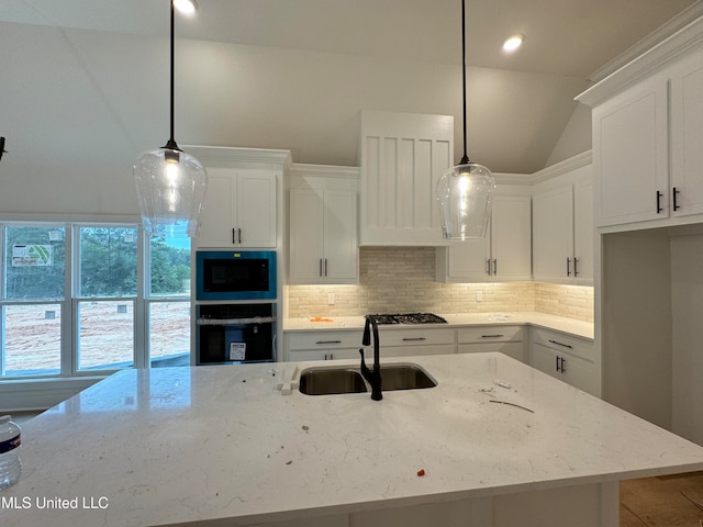 kitchen featuring sink, hanging light fixtures, black oven, light stone countertops, and white cabinets