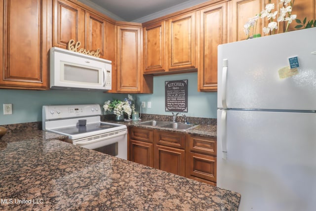 kitchen featuring dark stone countertops, white appliances, sink, and ornamental molding