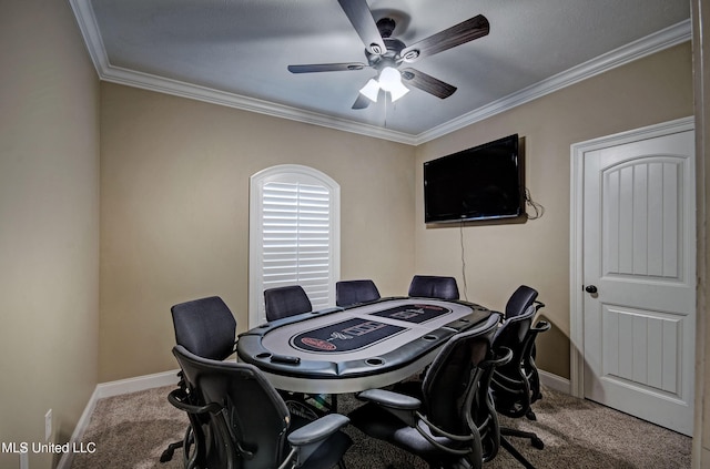 carpeted office space featuring baseboards, a ceiling fan, and crown molding