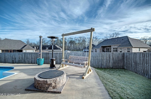 view of patio with a fenced in pool, a fire pit, and a fenced backyard